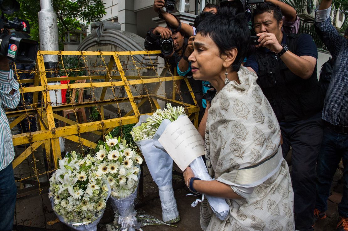 A woman leaves flowers at a roadblock near the cafe. Bangladesh was observing two days of national mourning. 