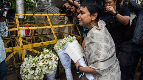 A woman leaves flowers at a roadblock near the cafe. Bangladesh was observing two days of national mourning. 