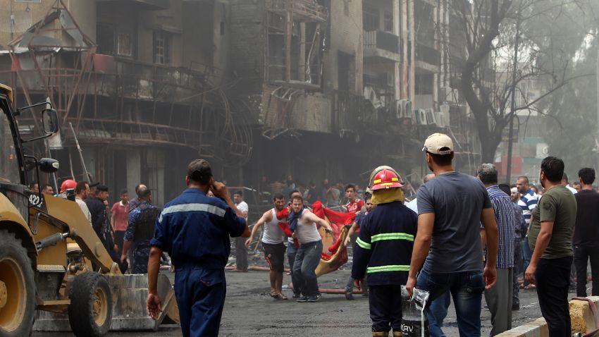Iraqis on Sunday evacuate a body from the site of a suicide car bombing in Baghdad's central Karrada district.