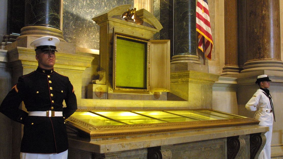 An honor guard stands next to the original copies of the Declaration of Independence, the Constitution and the Bill of Rights July 4, 2001 at the National Archives in Washington, D. C.  