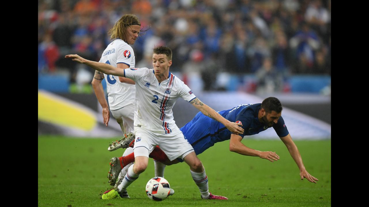 Andre-Pierre Gignac of France competes for the ball against Birkir Saevarsson and Birkir Bjarnason of Iceland.