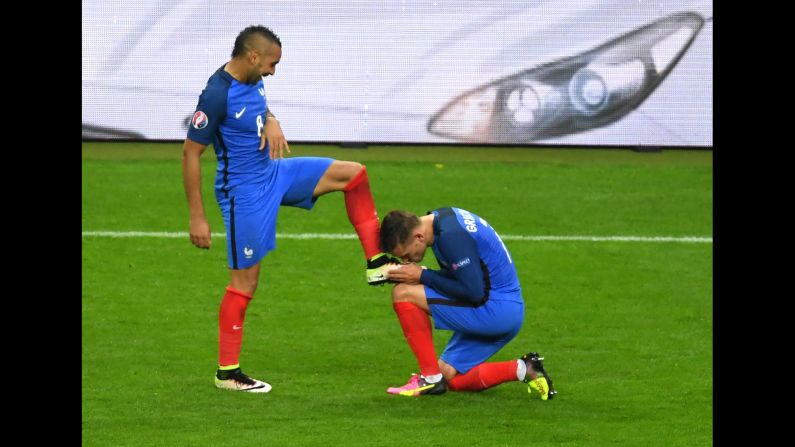 France's forward Dimitri Payet's shoe is kissed by teammate forward Antoine Griezmann as they celebrate France's third goal. 