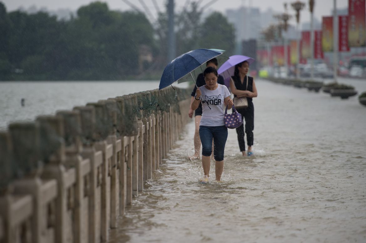 People cross a flooded bridge in Wuhan on July 2. 