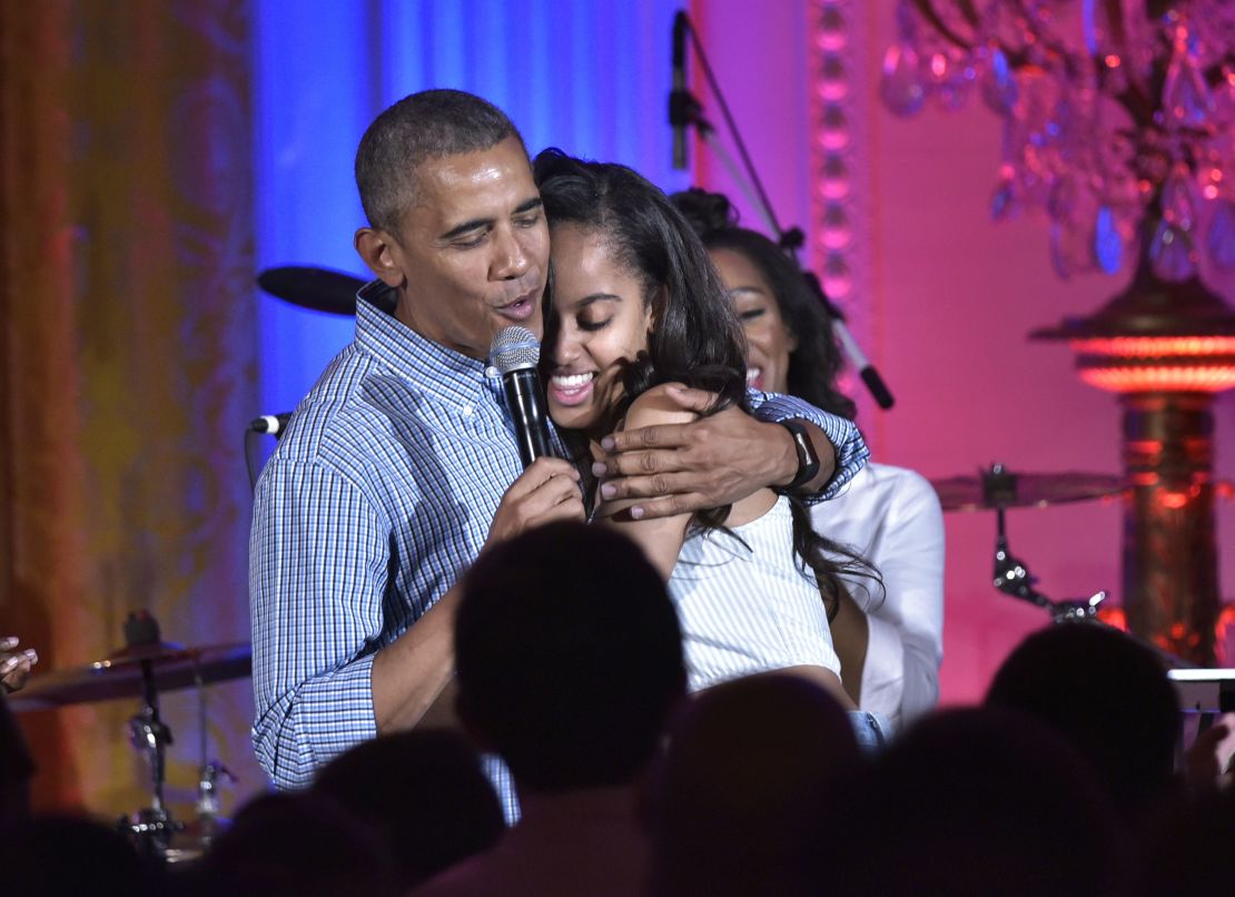 President Barack Obama hugs his daughter Malia on her birthday during an Independence Day Celebration for military members and administration staff on July 4, 2016 in the East Room of the White House in Washington, DC.