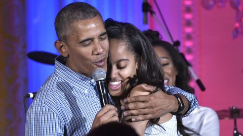 President Barack Obama hugs his daughter Malia on her birthday during an Independence Day Celebration for military members and administration staff on July 4, 2016 in the East Room of the White House in Washington, DC.