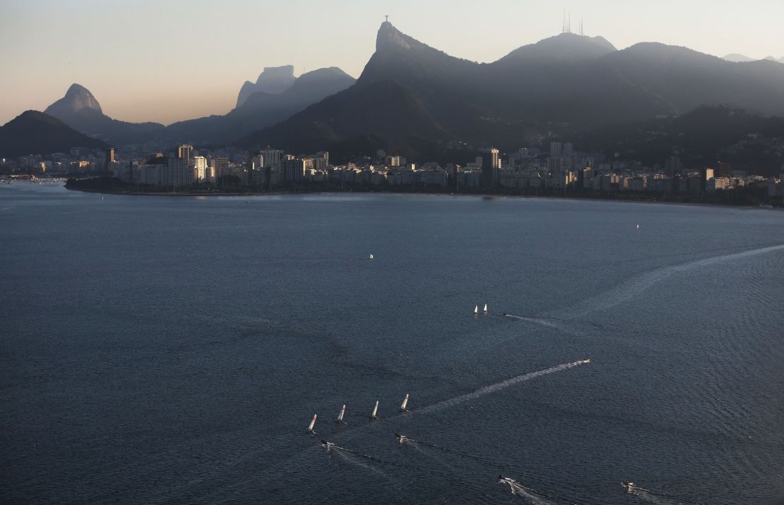 Sailboats sail in the polluted Guanabara Bay, venue site of the Olympic sailing events.