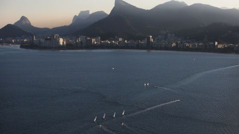 Sailboats sail in the polluted Guanabara Bay, venue site of the Olympic sailing events.