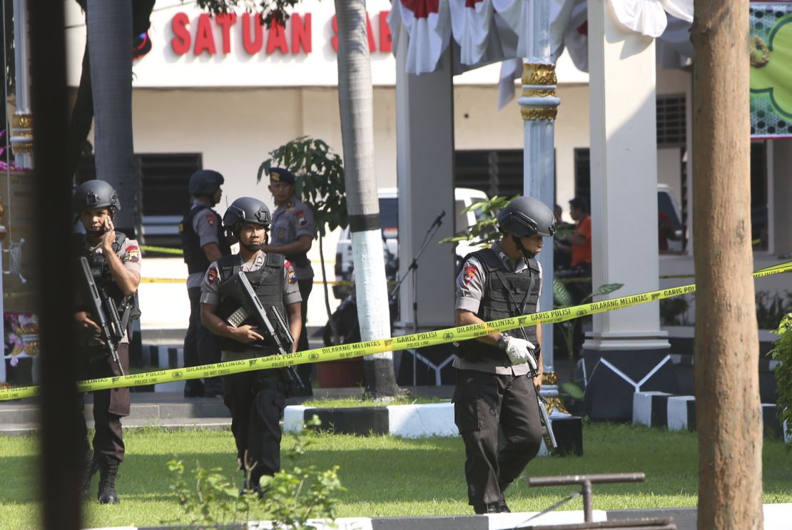 Members of police bomb squad examine an area near where a suicide bomber blew himself up in Solo, Indonesia.