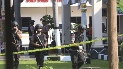 Members of police bomb squad examine an area near where a suicide bomber blew himself up in Solo, Indonesia.