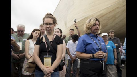 Visitors bow their heads in prayer during a ribbon-cutting ceremony on July 5.