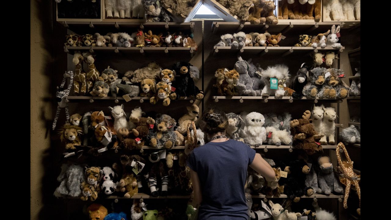 A worker puts out stuffed animals in the gift shop.