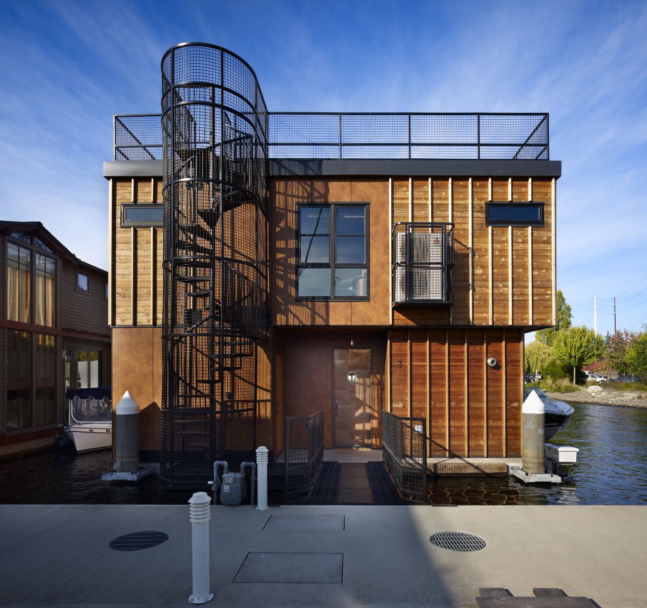 A project by Designs Northwest Architects, Lake Union Float Home is part of Seattle's unique houseboat community. Inspired by the century-old marina warehouses on the docks, the architects created a modern home with historical touches, evident in the industrial form, steel beams, polished concrete and caged spiral staircase.