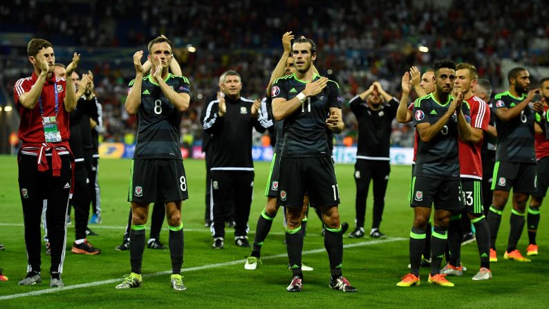 Welsh players applaud their fans after the loss in Lyon, France.