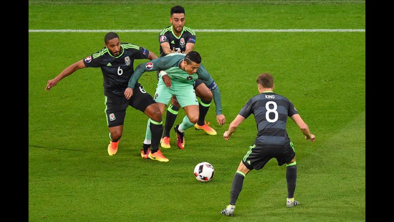 Ronaldo is swarmed by Welsh defenders.