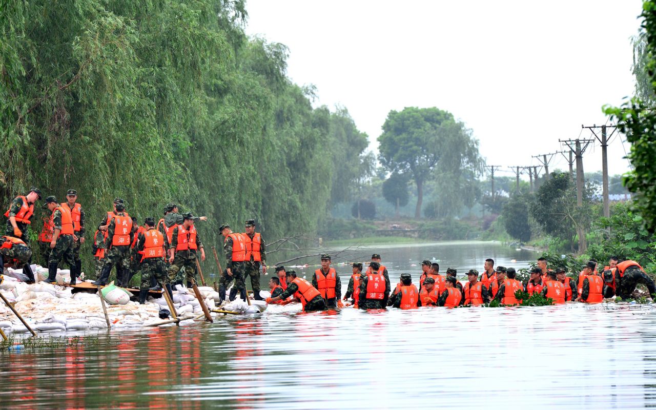 Chinese soldiers carry sandbags to reinforce a lake dyke in Wuhan on July 5.  