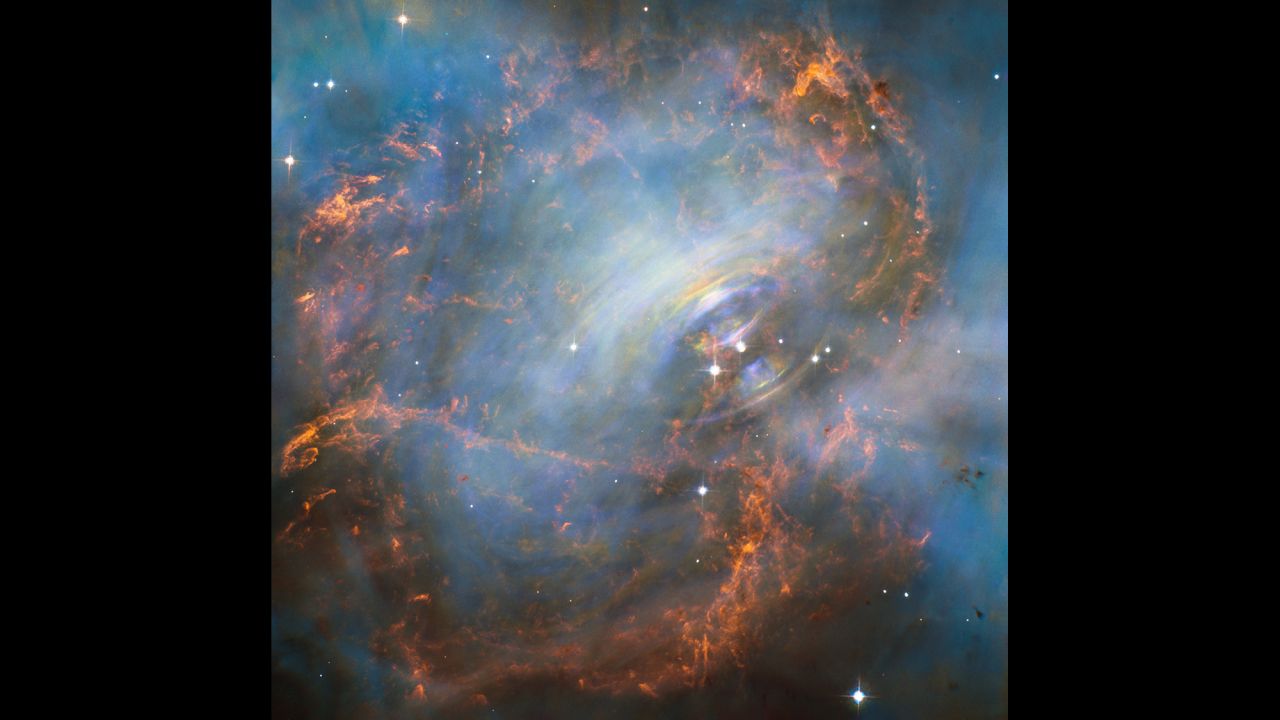 NASA's Hubble Space Telescope captured this image of the Crab Nebula and its "beating heart," which is a neutron star at the right of the two bright stars in the center of this image. The neutron star pulses 30 times a second. The rainbow colors are visible due to the movement of materials in the nebula occurring during the time-lapse of the image. 