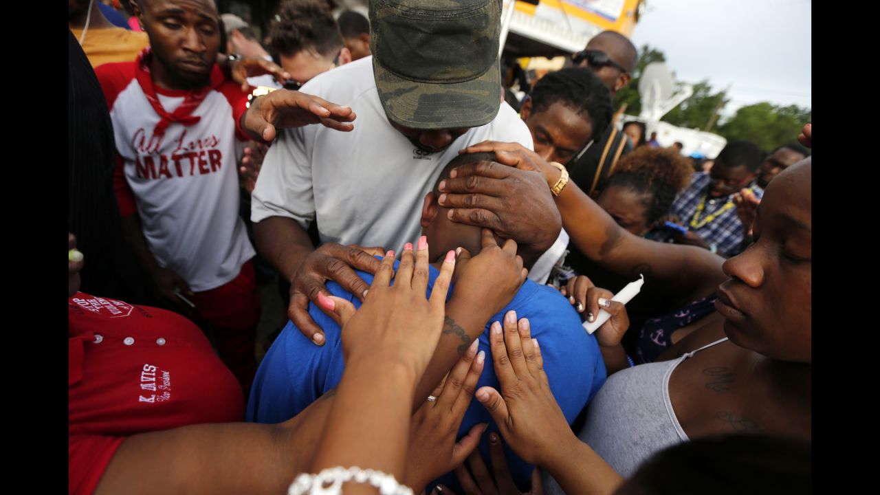 Hands of comfort extend to Cameron Sterling, the son of Alton Sterling, outside the convenience store where Alton Sterling was shot and killed by police. 