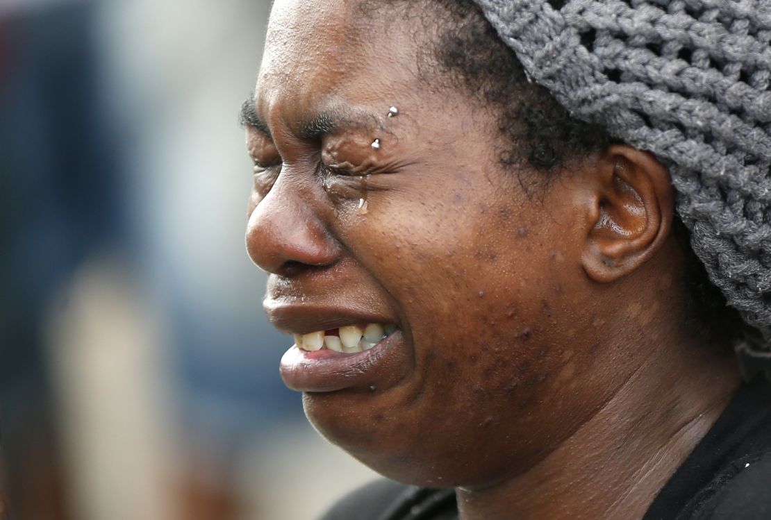 Tawandra Carr cries outside the Triple S Mart in Baton Rouge