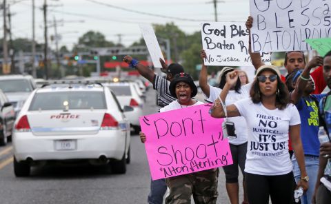 People in Baton Rouge demonstrate July 6 as police cars pass the convenience store where Alton Sterling was shot.