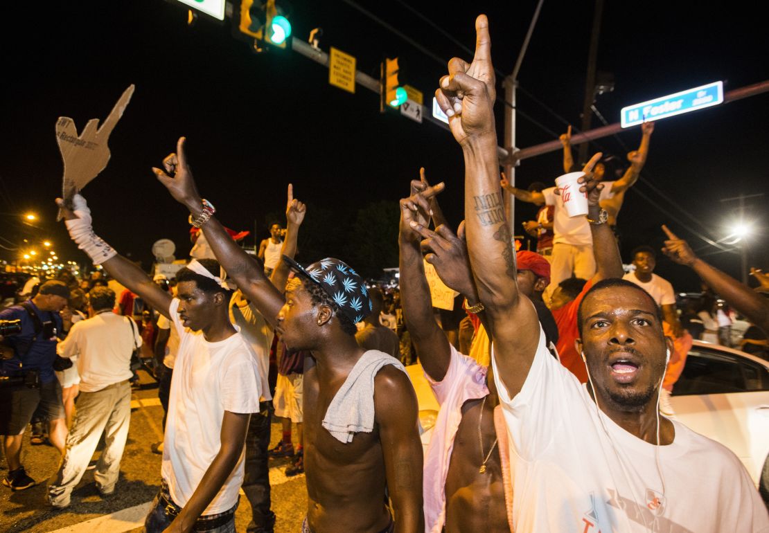 Protesters block traffic and dance on cars near the Triple S Food Mart in Baton Rouge.