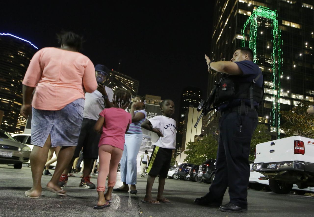 Dallas police order people away from the area after the shootings.