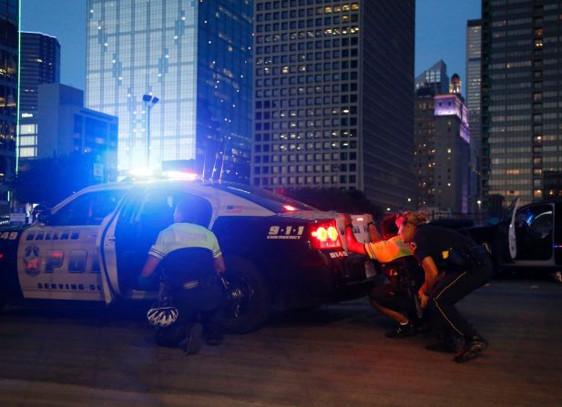 Police officers take cover as shots are fired. 