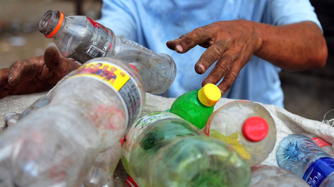 A man collects plastic bottles to sell for recycling, in a landfill of Managua, on January 11, 2013.  AFP PHOTO/Hector RETAMAL        (Photo credit should read HECTOR RETAMAL/AFP/Getty Images)