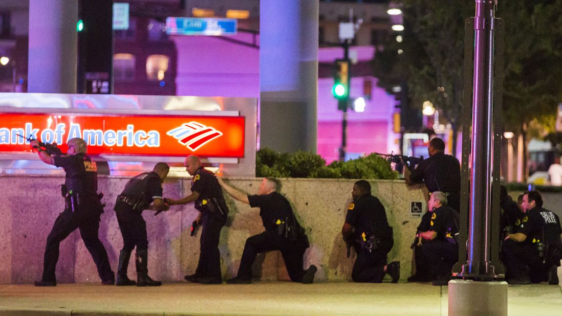 Dallas Police take position after shots are fired. Pool said the police were "very focused, very on their game." This image, showing a line of officers against the wall with their guns drawn, was made as Pool looked down the street while he was squeezed between some cars and behind a police officer for cover.