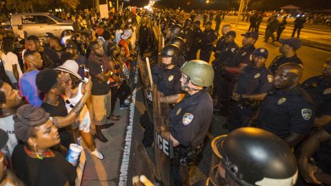 Protesters face off with Baton Rouge police across the street from the police department on Saturday.