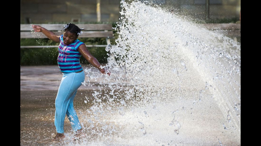 Jonasha Wright, 8, plays in a fountain a few feet away from a protest rally. "One of the very first photographs I was making was of a little girl spinning and twirling and smiling and laughing in a fountain in the park where the rally was. There she was, a few feet from this Black Lives Matter rally that was about to start, and she's just a little girl enjoying a summer day like every other little girl should be doing on a summer day."