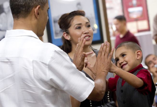 A little boy gives U.S. President Barack Obama a high five as Obama greets members of the U.S. military and their families at a Christmas Day meal at Marine Corps Base Hawaii at Kaneohe Bay, Hawaii, December 25, 2010. 