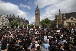 Demonstrators sit in the road on Parliament Square in central London on Sunda.