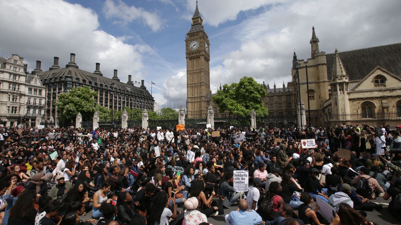 Demonstrators sit in the road on Parliament Square in central London on Sunda.