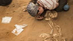 A student archaeologist brushes dirt away from a skeleton buried in the first ever Philistine cemetery, found at Ashkelon in Israel.