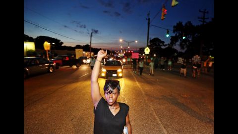 Sirica Bolling raises her fist as she walks down Jefferson Avenue during a Black Lives Matter protest in Newport News, Va., Sunday July 10, 2016, following the fatal shootings of Alton Sterling in Louisiana and Philando Castile in Minnesota. 