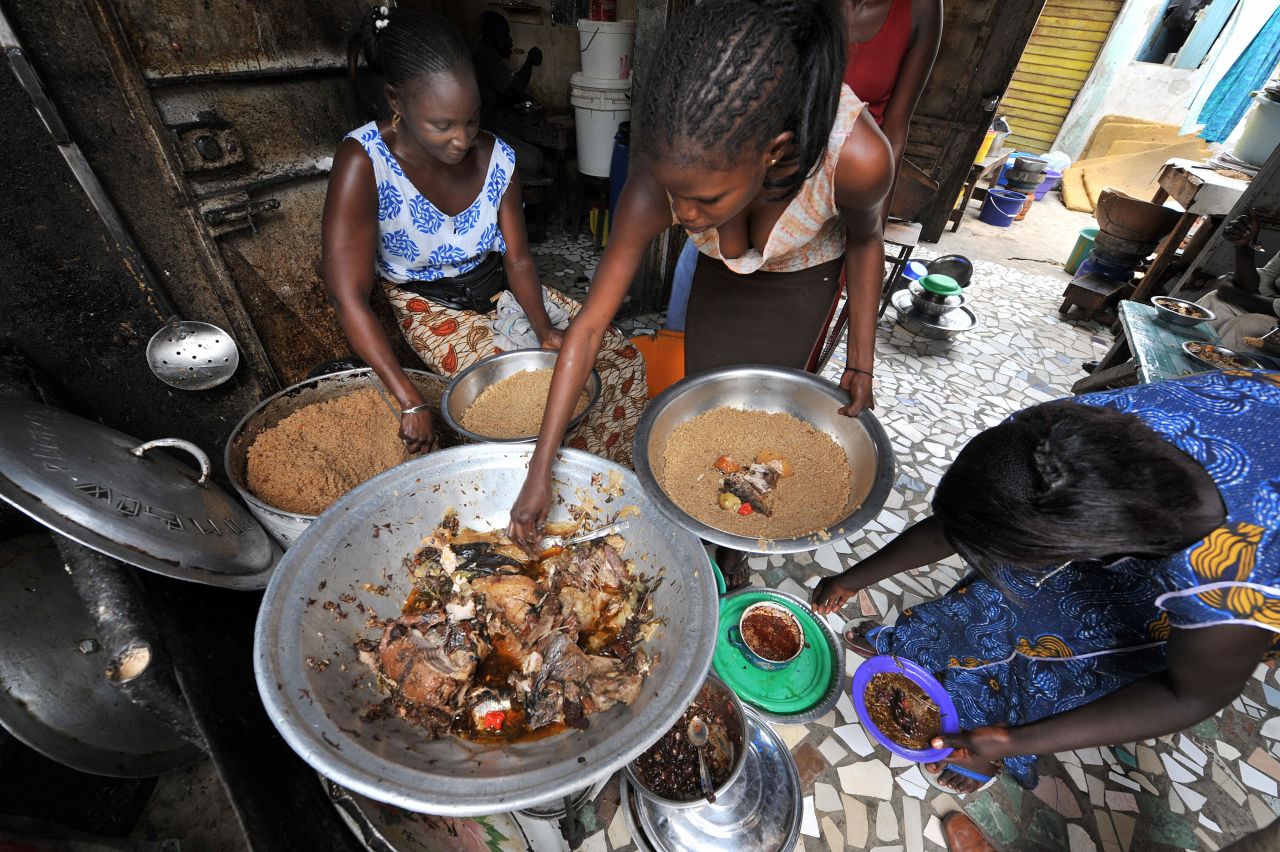 "As income goes up, we can consume and buy more good things, healthier things like fruits, vegetables, fresh fish, stuff like that. But we can and do also buy unhealthy things -- processed meats, sugary drinks, highly processed food," Haddad says.  <br /><br />Pictured here, women prepare a traditional Senegalese dish of rice and fish at a street restaurant in Dakar.