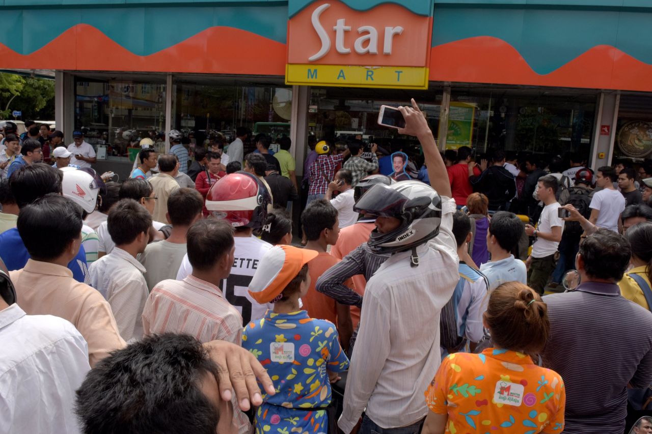 Cambodian people gather outside a convenience store where Kem Ley was killed. 
