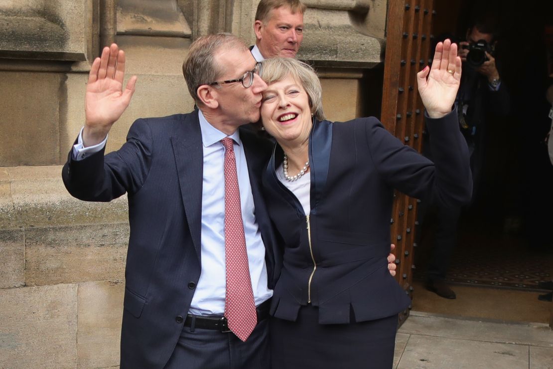 Philip May gives his wife a kiss Monday before she speaks about assuming party leadership. 