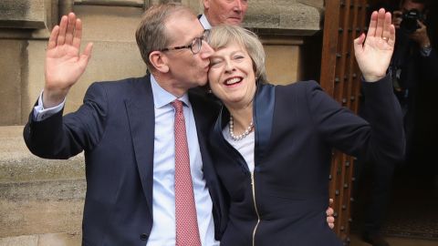 Philip May gives his wife a kiss Monday before she speaks about assuming party leadership.