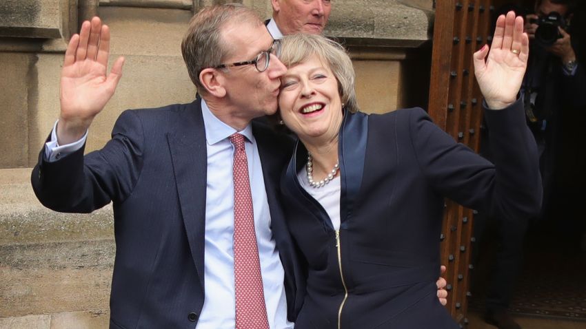 Philip May gives his wife a kiss Monday before she speaks about assuming party leadership.