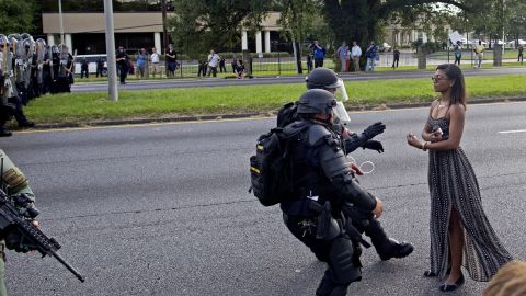 Riot police grab a protester after she refused to leave the road in Baton Rouge.