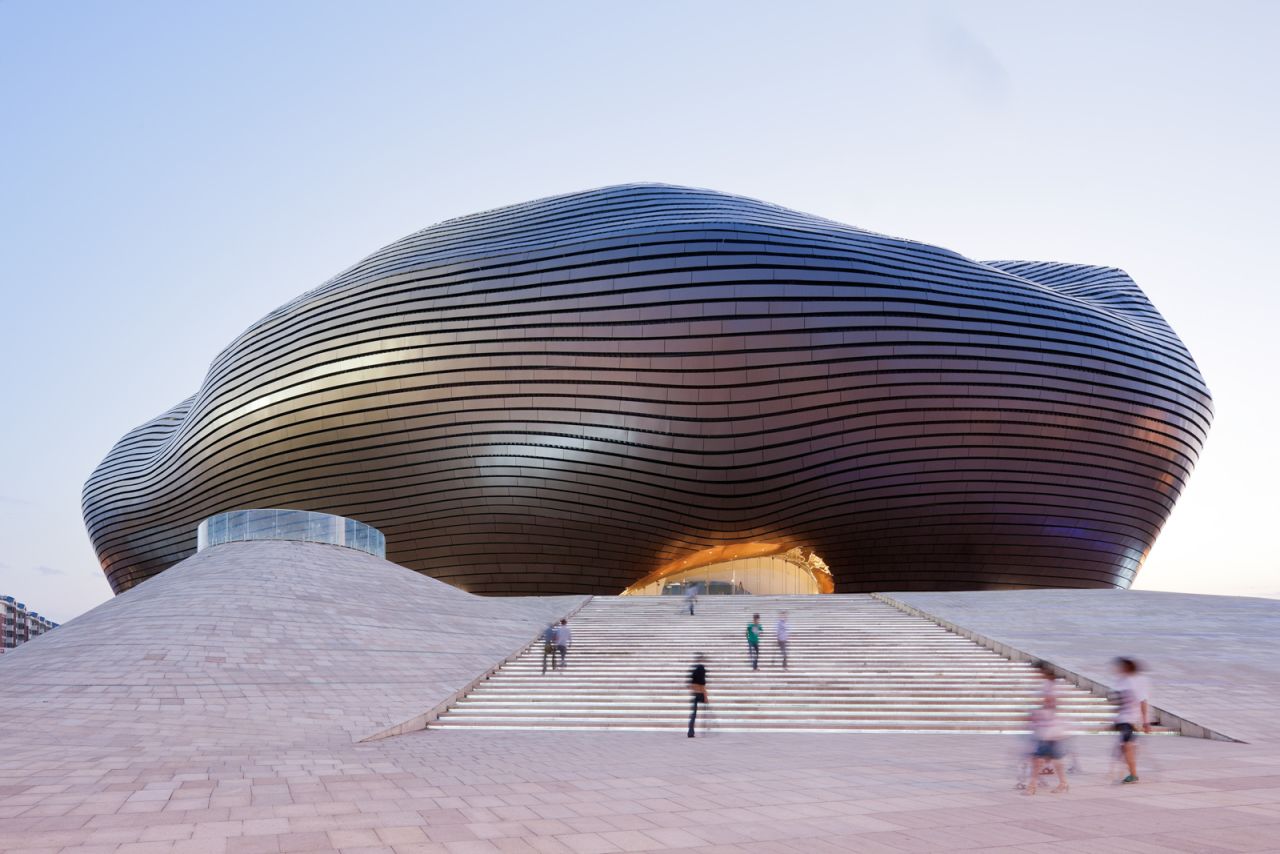 The polished bronze metal facade of the Ordos Museum is intended to represent the rising sun over the surrounding grasslands.  