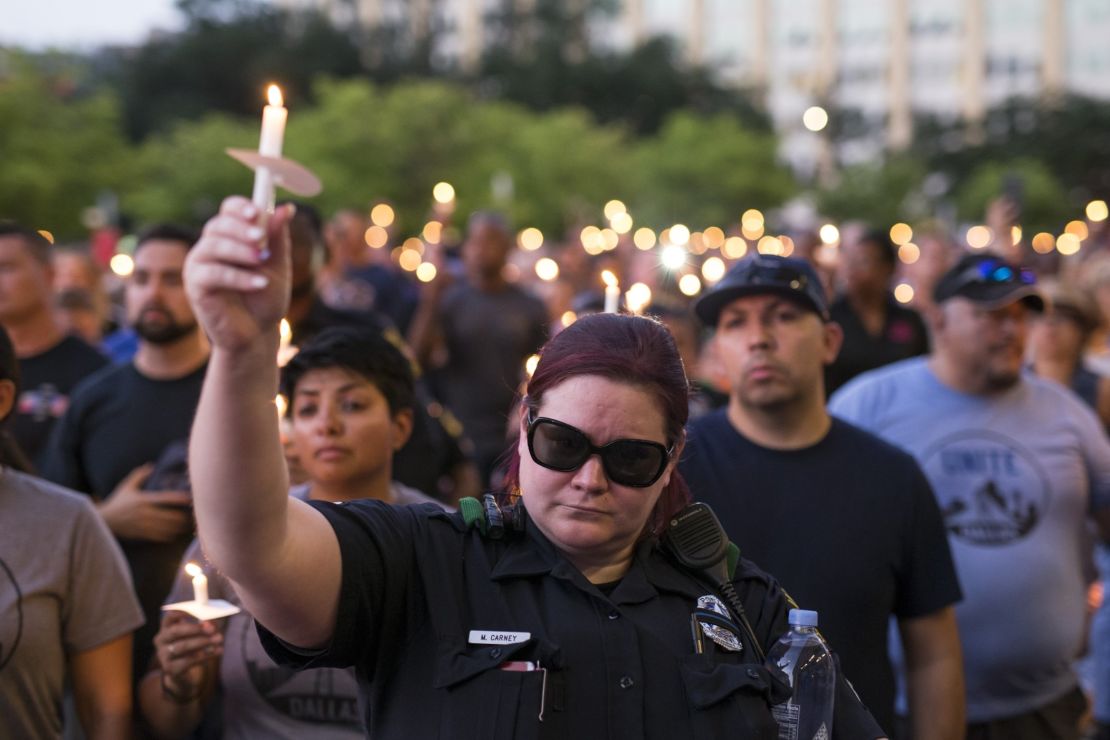 Mourners attend a Monday candlelight vigil for five officers killed last week during protests in Dallas.