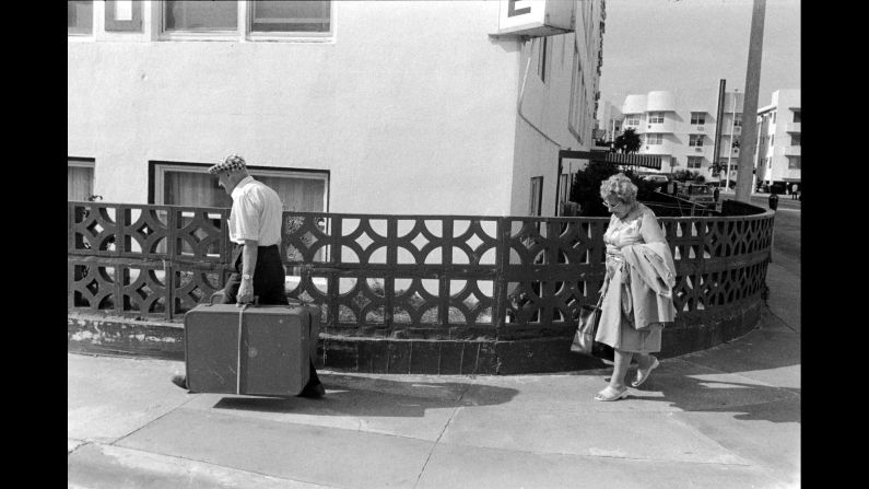 A couple walks with their luggage at 15th Street and Ocean Drive in 1981. "More recently I've taken to the old couple walking seemingly aimlessly across the sidewalk," Monroe said about this image. "He's carrying the weight of the luggage and the world, while his wife (one assumes) walks about 10 feet behind him. It's a quiet but poignant image."
