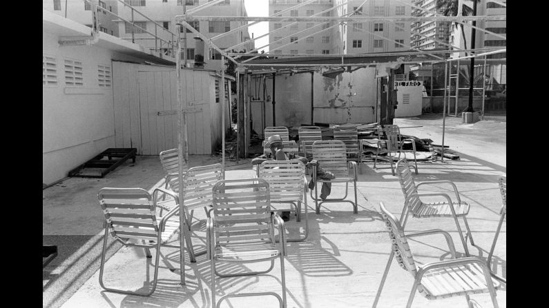 A man is surrounded by chairs in 1982. Monroe describes the South Beach of now as a place comprised of "clubbing 'til dawn, drinking from supersized fishbowl glasses and finding a parking space."