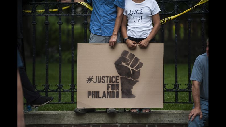 A couple hold a sign protesting the <a href="http://www.cnn.com/2016/07/07/us/falcon-heights-shooting-minnesota/" target="_blank">killing of Philando Castile</a> outside the governor's mansion on July 7, in St. Paul, Minnesota. Castile's death was live-streamed by his fiancée and quickly went viral.