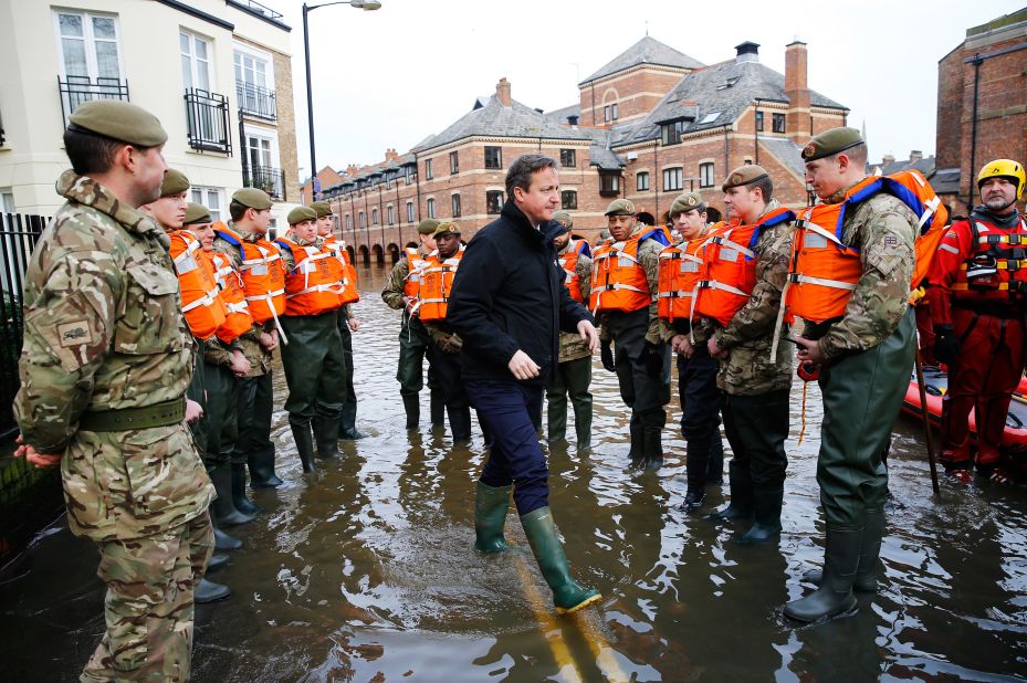 Cameron puts on a pair of wellington boots after severe flooding hit large parts of northern England in December 2015. 