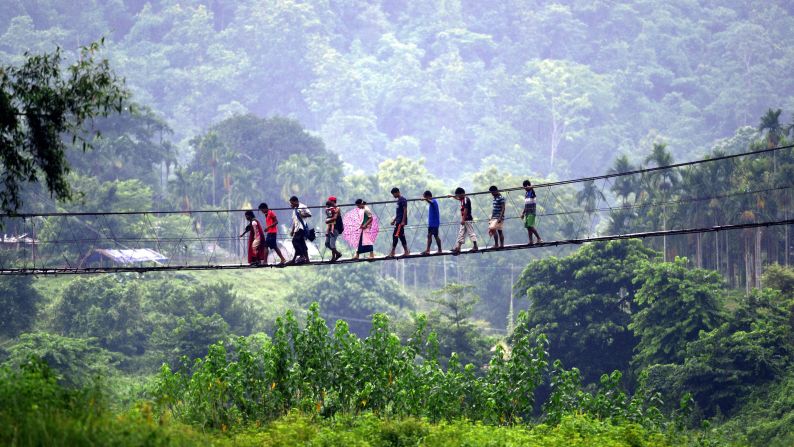 In the rural South Kamrup district, villagers from Meghalaya state cross a bridge over the Shree river to visit a weekly market in Ukiam.