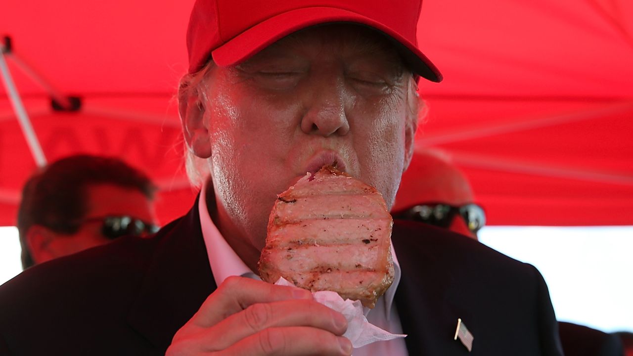 Republican presidential candidate Donald Trump eats a pork chop on a stick while campaigning the Iowa State Fair on August 15, 2015 in Des Moines, Iowa.
