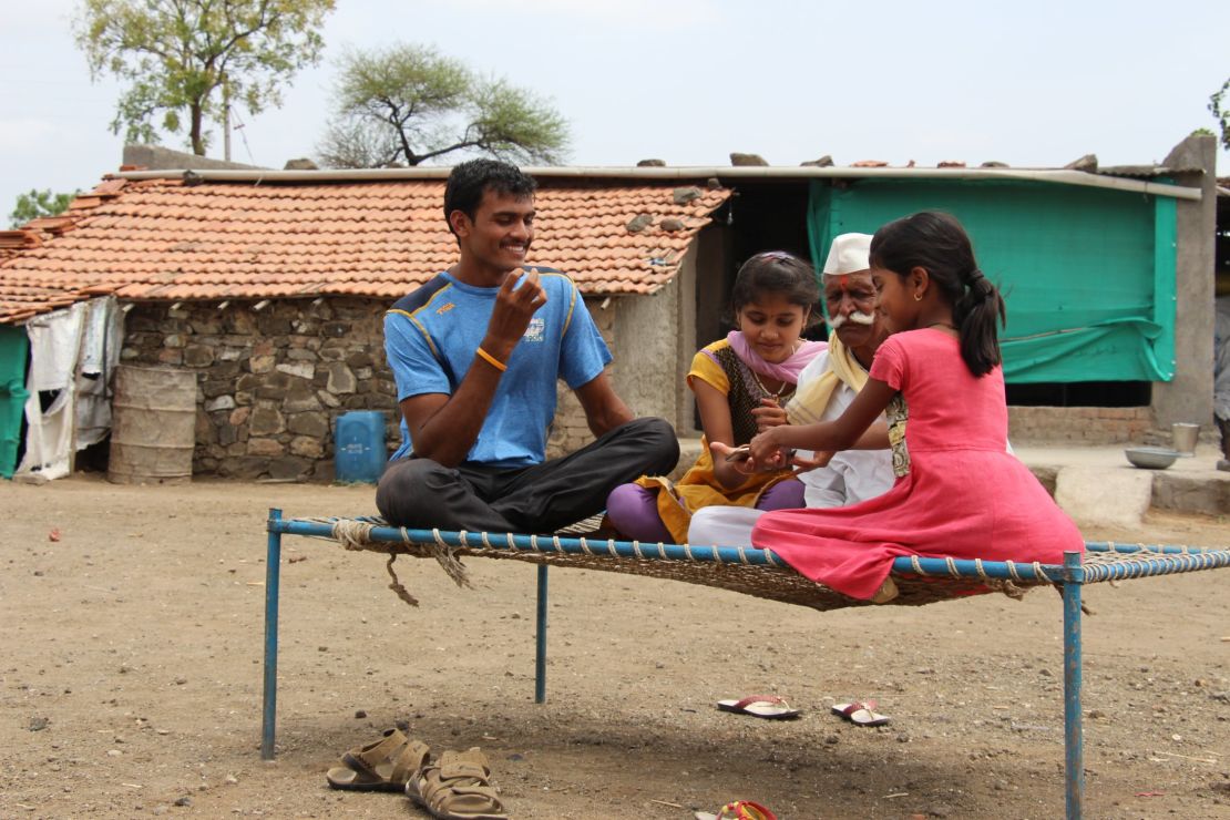 Bokhanal sits with his nieces and grandfather. He says he competes to support his family.